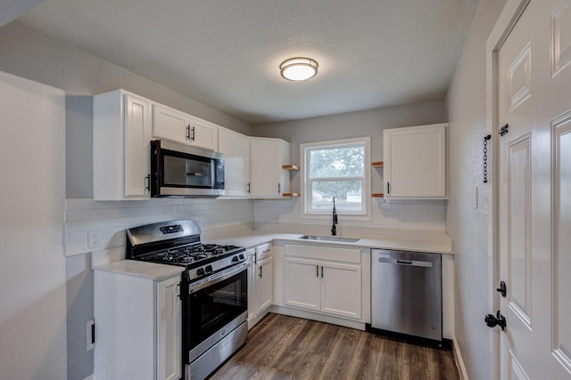 308 Chandler Dr, Garland, TX 75040 - kitchen featuring appliances with stainless steel finishes, open shelves, a sink, dark wood finished floors, and white cabinetry