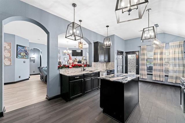 117 Baccus Dr, Mesquite, TX 75150 - kitchen with a chandelier, arched walkways, a sink, dark cabinetry, and dark wood-style floors