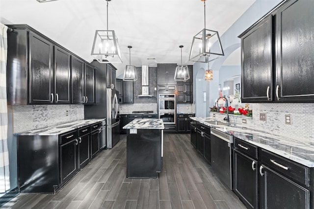 117 Baccus Dr, Mesquite, TX 75150 - kitchen with dark cabinetry, appliances with stainless steel finishes, wall chimney range hood, a sink, and tasteful backsplash