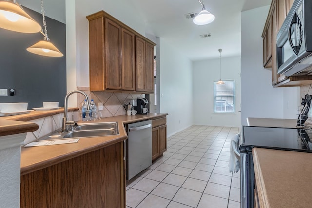 2111 Preston Trl, Forney, TX 75126 - kitchen with appliances with stainless steel finishes, a sink, decorative backsplash, light tile patterned flooring, and decorative light fixtures