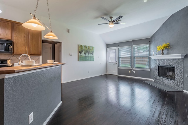 2111 Preston Trl, Forney, TX 75126 - unfurnished living room with ceiling fan, vaulted ceiling, dark wood-type flooring, a fireplace, and baseboards