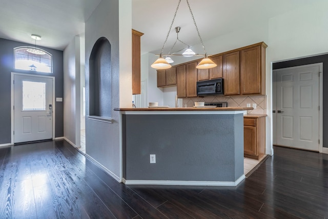 2111 Preston Trl, Forney, TX 75126 - kitchen featuring black microwave, brown cabinetry, dark wood-style flooring, and decorative backsplash