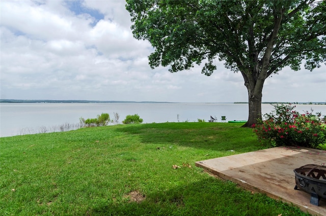 114 Harbor Dr Unit 117, Runaway Bay, TX 76426 - view of green lawn featuring a water view, an outdoor fire pit, and a patio area