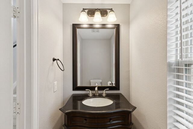 3711 Venice Dr, Irving, TX 75038 - bathroom with vanity, toilet, and a textured wall