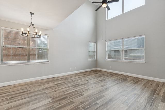 3711 Venice Dr, Irving, TX 75038 - spare room featuring a chandelier, ceiling fan, wood finished floors, baseboards, and a high ceiling