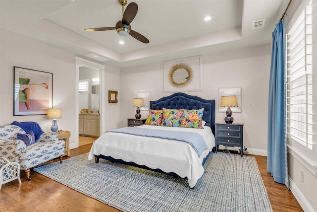2116 Tremont Blvd, Mckinney, TX 75071 - bedroom featuring a tray ceiling, wood finished floors, connected bathroom, recessed lighting, and ceiling fan