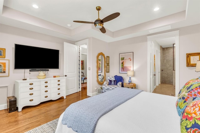 2116 Tremont Blvd, Mckinney, TX 75071 - bedroom featuring a raised ceiling, light wood-style flooring, recessed lighting, ceiling fan, and connected bathroom