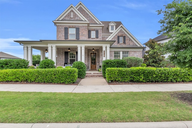 2116 Tremont Blvd, Mckinney, TX 75071 - view of front facade with brick siding, a porch, and a front lawn