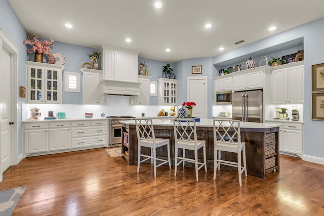 2116 Tremont Blvd, Mckinney, TX 75071 - kitchen featuring premium appliances, an island with sink, light countertops, a kitchen breakfast bar, and white cabinets