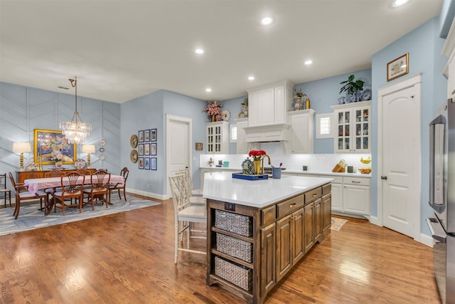 2116 Tremont Blvd, Mckinney, TX 75071 - kitchen with premium range hood, freestanding refrigerator, white cabinets, light countertops, and glass insert cabinets