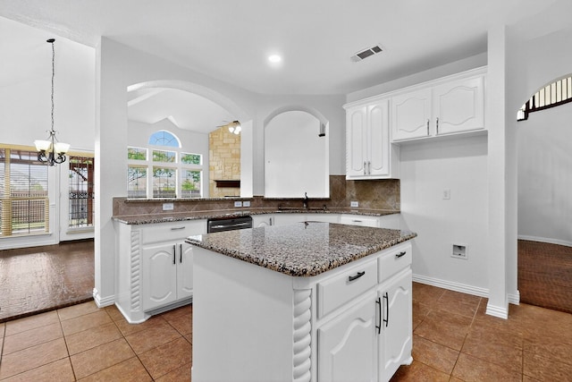 3436 Copper Point Ln, Frisco, TX 75034 - kitchen featuring a kitchen island, dark stone counters, dishwasher, white cabinetry, and decorative backsplash