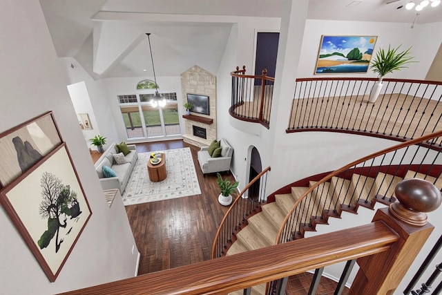 3436 Copper Point Ln, Frisco, TX 75034 - living room with wood finished floors, a stone fireplace, stairs, and vaulted ceiling