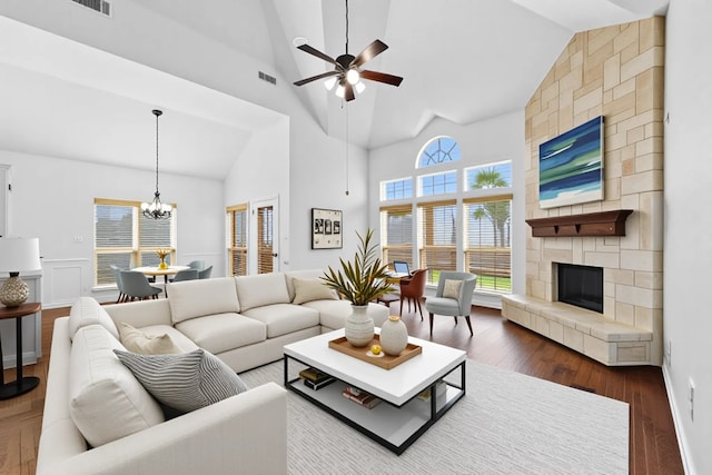 3436 Copper Point Ln, Frisco, TX 75034 - living room with ceiling fan, high vaulted ceiling, a stone fireplace, a chandelier, and dark wood finished floors