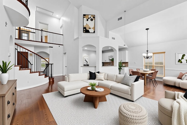 3436 Copper Point Ln, Frisco, TX 75034 - living room with wood finished floors, a towering ceiling, a chandelier, stairway, and baseboards