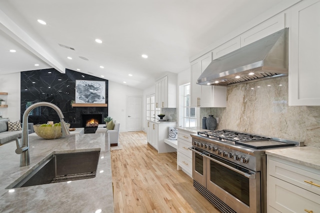 4336 Irvin Simmons Dr, Dallas, TX 75229 - kitchen featuring double oven range, wall chimney range hood, open floor plan, a fireplace, and recessed lighting