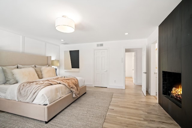 4336 Irvin Simmons Dr, Dallas, TX 75229 - bedroom with light wood-type flooring, a large fireplace, and recessed lighting