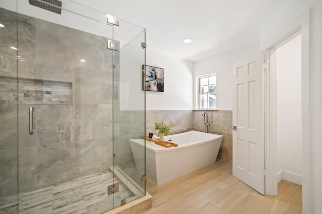 4336 Irvin Simmons Dr, Dallas, TX 75229 - bathroom featuring a soaking tub, tile walls, a stall shower, wood finished floors, and wainscoting
