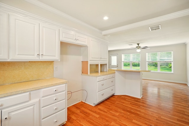 2050 Greenbriar Dr, Abilene, TX 79605 - kitchen with light wood finished floors, ornamental molding, white cabinets, recessed lighting, and tasteful backsplash