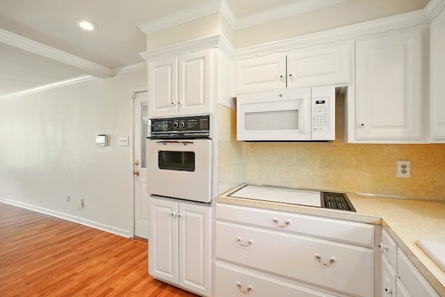 2050 Greenbriar Dr, Abilene, TX 79605 - kitchen with white appliances, light countertops, white cabinets, crown molding, and light wood-style flooring
