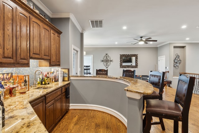 400 Whitley Place Dr, Prosper, TX 75078 - kitchen with a sink, light wood-style flooring, light stone countertops, a breakfast bar, and recessed lighting