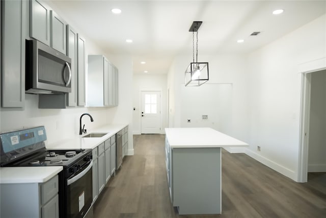 309 E Cheek St, Saint Jo, TX 76265 - kitchen with stainless steel microwave, stove, gray cabinetry, a sink, and a center island