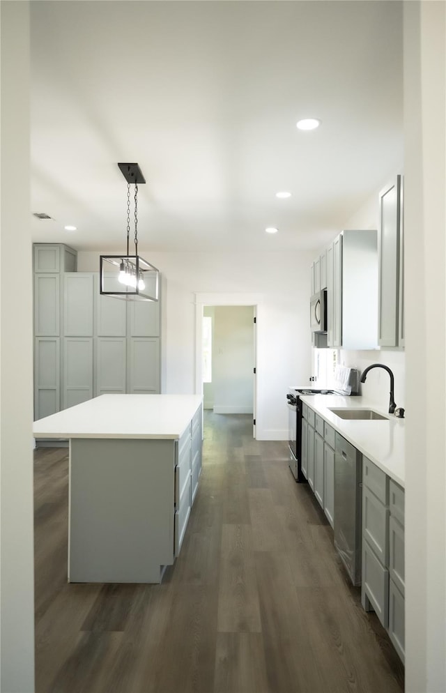309 E Cheek St, Saint Jo, TX 76265 - kitchen featuring a sink, stainless steel appliances, a center island, dark wood-style flooring, and light countertops