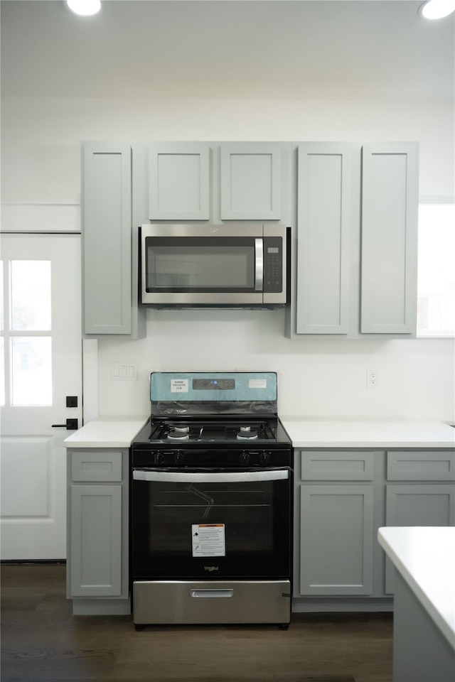 309 E Cheek St, Saint Jo, TX 76265 - kitchen with appliances with stainless steel finishes, light countertops, dark wood-type flooring, and gray cabinetry
