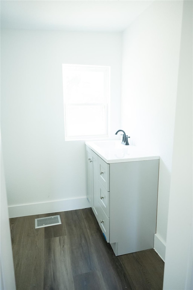 309 E Cheek St, Saint Jo, TX 76265 - bathroom with wood finished floors, vanity, and baseboards