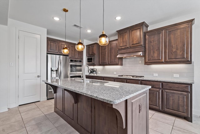 350 Lake Trail Ln, Prosper, TX 75078 - kitchen with appliances with stainless steel finishes, a sink, under cabinet range hood, light tile patterned floors, and dark brown cabinets