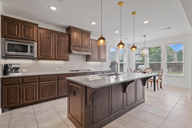 350 Lake Trail Ln, Prosper, TX 75078 - kitchen featuring stainless steel appliances, a sink, light tile patterned floors, light stone countertops, and decorative backsplash