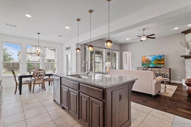 350 Lake Trail Ln, Prosper, TX 75078 - kitchen featuring stainless steel dishwasher, a sink, light tile patterned floors, light stone counters, and dark brown cabinets