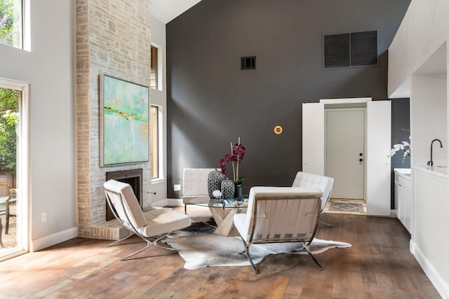 5325 Seascape Ln, Plano, TX 75093 - sitting room featuring high vaulted ceiling, wood finished floors, baseboards, and a brick fireplace