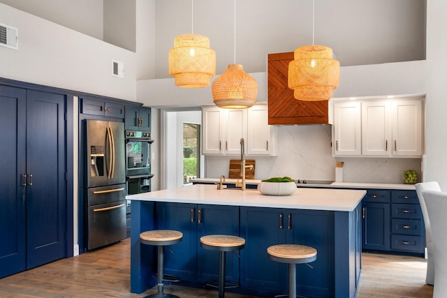 5325 Seascape Ln, Plano, TX 75093 - kitchen featuring stainless steel fridge with ice dispenser, blue cabinetry, light countertops, a towering ceiling, and backsplash