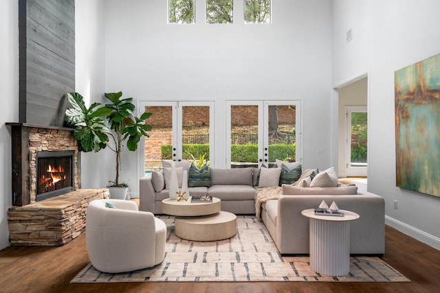 5325 Seascape Ln, Plano, TX 75093 - living room featuring a high ceiling, french doors, wood finished floors, a stone fireplace, and baseboards