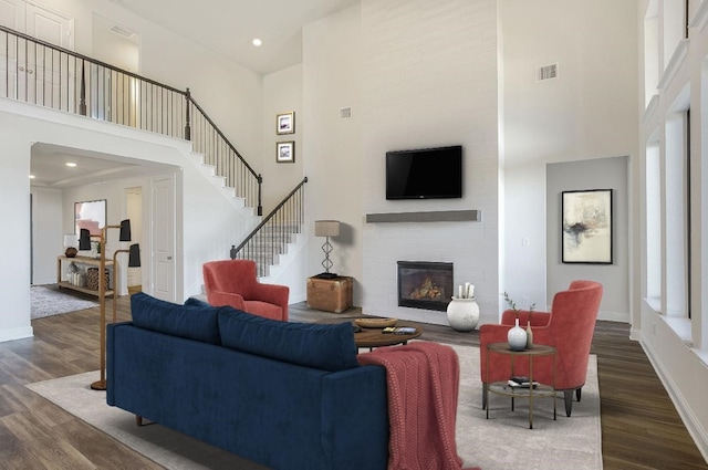 2804 Walker Way, Northlake, TX 76247 - living area with a towering ceiling, dark wood-style flooring, a large fireplace, baseboards, and stairs