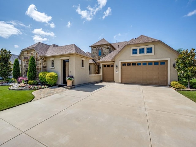 9813 Ironwood Dr, Denton, TX 76207 - view of front of house featuring stucco siding, concrete driveway, stone siding, and an attached garage