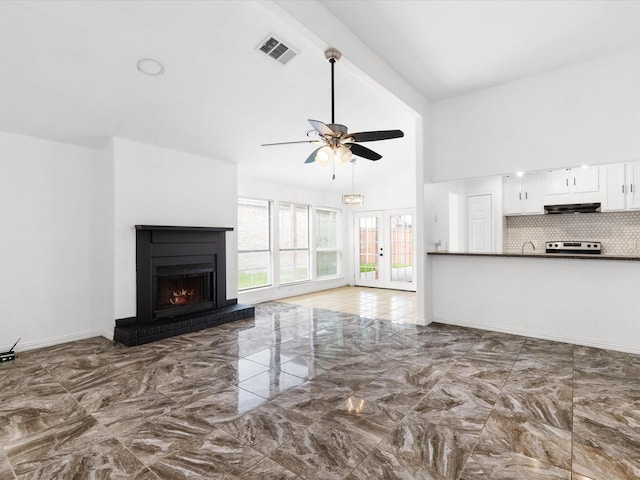 1640 Lemonwood Cir, Mesquite, TX 75149 - unfurnished living room featuring marble tiled floors, ceiling fan, a warm lit fireplace, a sink, and high vaulted ceiling