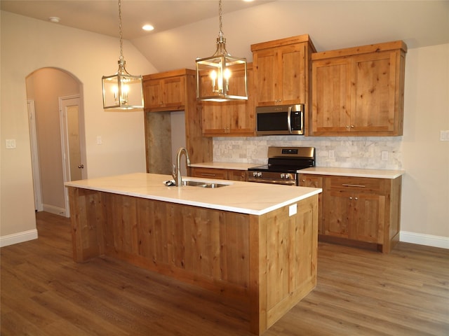 701 Raylan St, Springtown, TX 76082 - kitchen with appliances with stainless steel finishes, a sink, tasteful backsplash, light wood-style flooring, and arched walkways