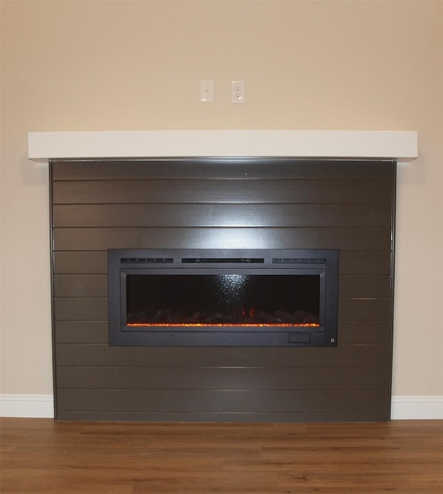 701 Raylan St, Springtown, TX 76082 - detailed view of a glass covered fireplace, wood finished floors, and baseboards
