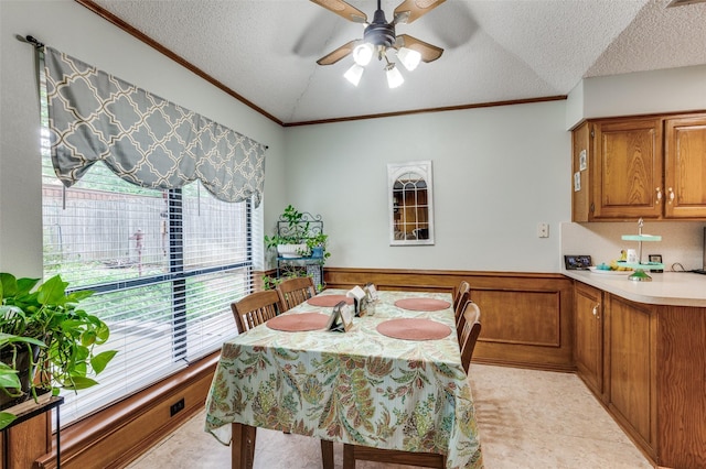 1001 Woodhaven Ct, Euless, TX 76039 - dining space with ceiling fan, a textured ceiling, crown molding, and a wainscoted wall