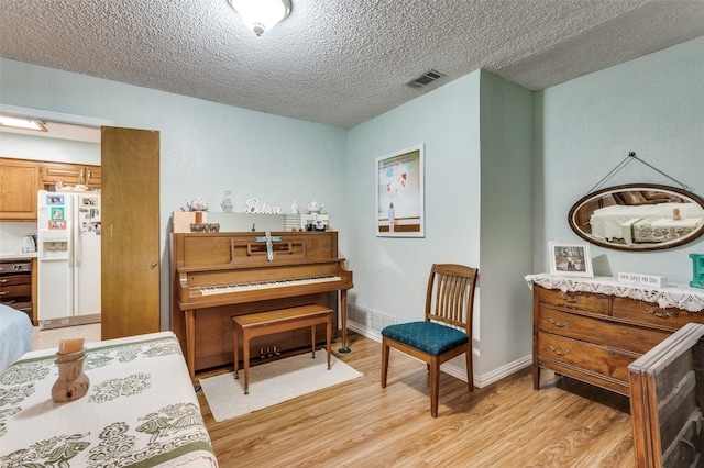 1001 Woodhaven Ct, Euless, TX 76039 - sitting room featuring light wood-type flooring, a textured ceiling, and baseboards