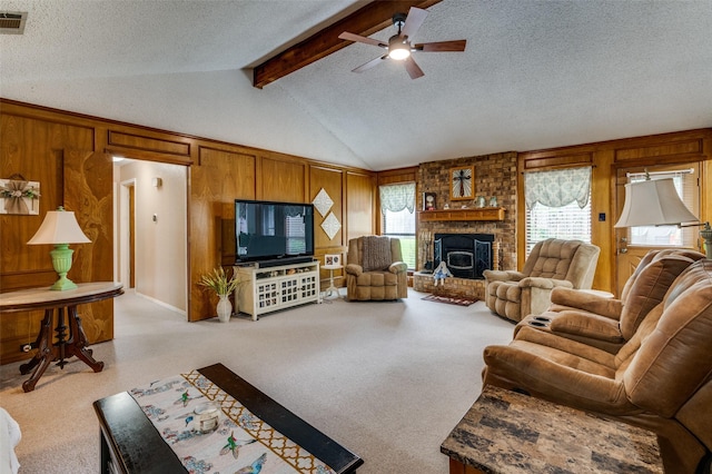 1001 Woodhaven Ct, Euless, TX 76039 - living room featuring ceiling fan, a textured ceiling, wooden walls, a fireplace, and light colored carpet