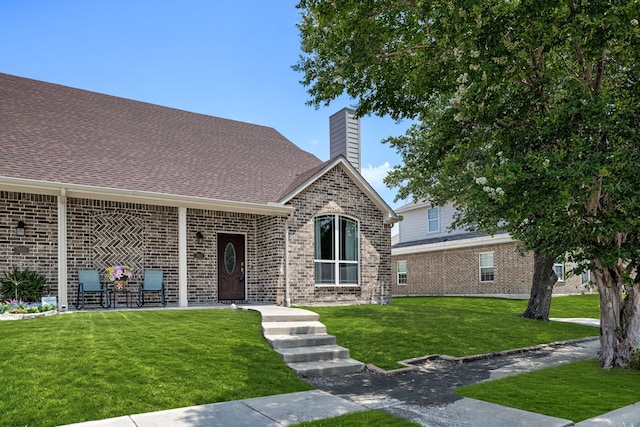 7603 Cousteau Dr, Rowlett, TX 75088 - view of front of house with a front lawn, a chimney, brick siding, and roof with shingles