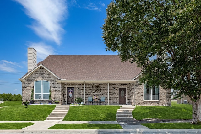 7603 Cousteau Dr, Rowlett, TX 75088 - view of front of house featuring a front lawn, a chimney, brick siding, and a shingled roof