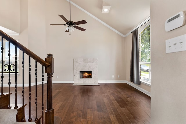 7603 Cousteau Dr, Rowlett, TX 75088 - unfurnished living room with dark wood-type flooring, healthy amount of natural light, high vaulted ceiling, a ceiling fan, and a tile fireplace