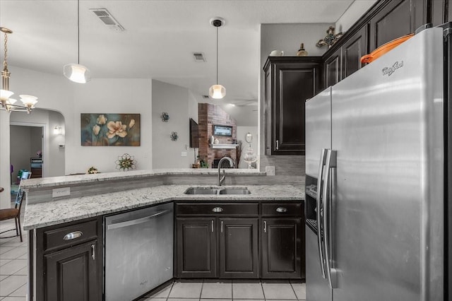5212 Cross Timber Rd W, Cleburne, TX 76031 - kitchen with stainless steel appliances, light tile patterned floors, light stone countertops, and hanging light fixtures