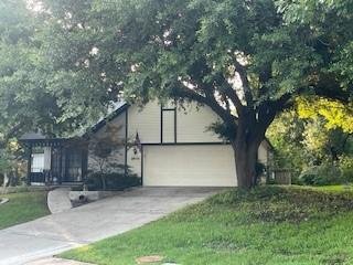2510 Plumdale Dr, Carrollton, TX 75006 - obstructed view of property featuring concrete driveway, an attached garage, and a front yard