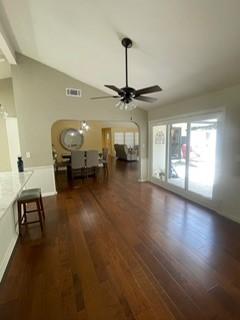 2510 Plumdale Dr, Carrollton, TX 75006 - unfurnished living room with a ceiling fan, wood finished floors, vaulted ceiling, and arched walkways