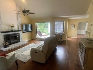 2510 Plumdale Dr, Carrollton, TX 75006 - living room with vaulted ceiling, a ceiling fan, dark wood-type flooring, a fireplace, and arched walkways