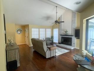 2510 Plumdale Dr, Carrollton, TX 75006 - living area featuring ceiling fan, wood finished floors, a fireplace with raised hearth, and high vaulted ceiling